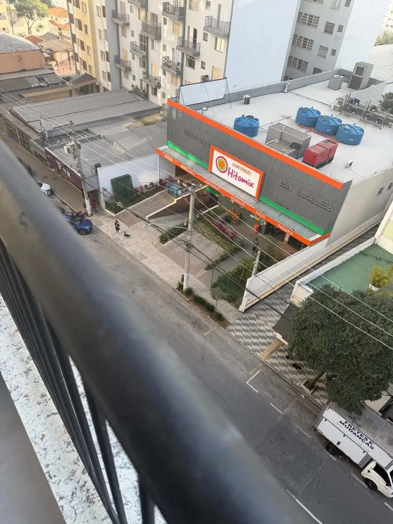 Vista da varanda com hortifrúti na porta do prédio