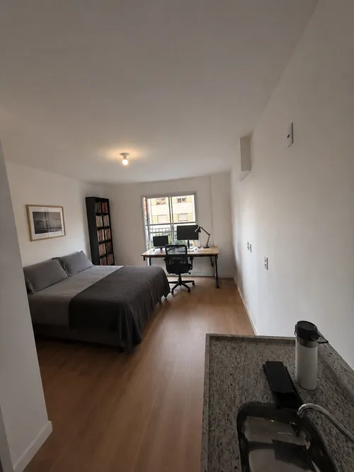 Studio 26 m² ambientado como home office: escrivaninha e cama