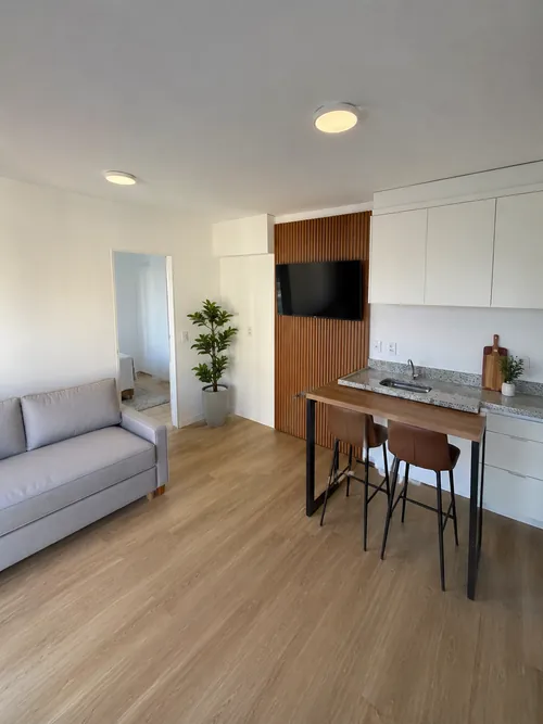 Sala do 28,24 m² ambientada: sofá, painel de TV e bancada com mesa alta